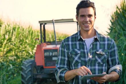 Junger Landwirt vor Traktor